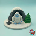 Cute abominable snowman yeti keychain, 3D printed by RU3D – front view with ice cave playset. White fur with blue face and feet.