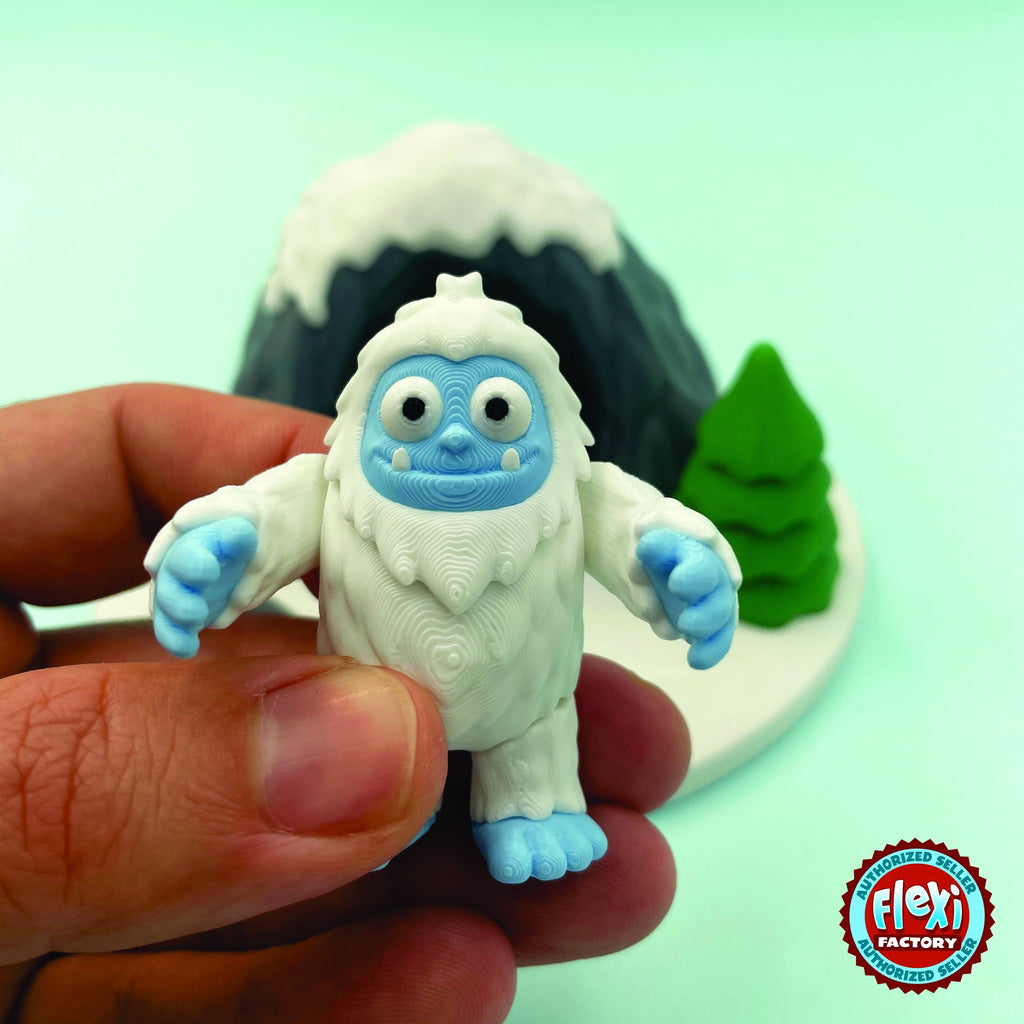 Cute abominable snowman yeti keychain, 3D printed by RU3D – held in hand. White fur with blue face and feet.