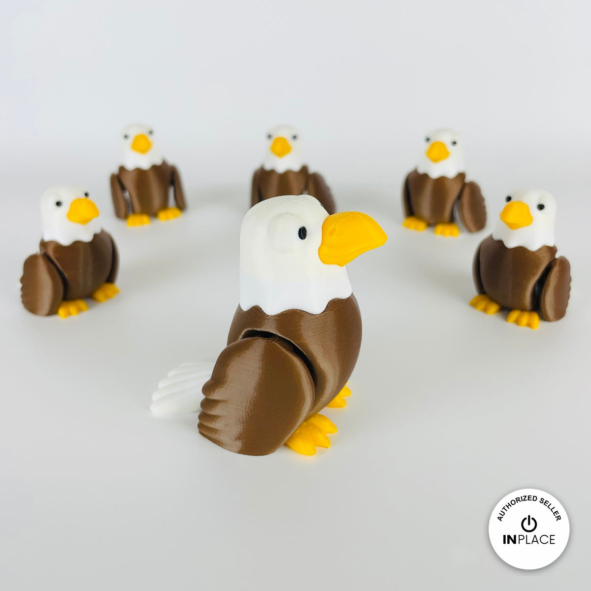 Cute bald eagle keychain, 3D printed by RU3D – group of bald eagles looking right. Brown body, white head and yellow beak.