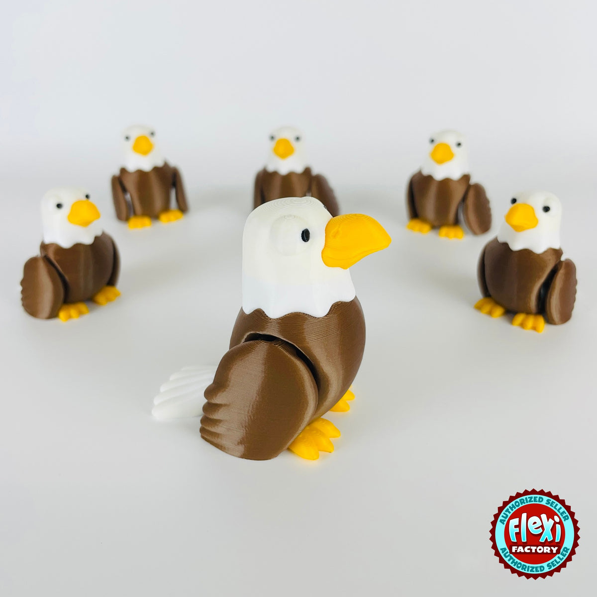 Cute bald eagle keychain, 3D printed by RU3D – group of bald eagles looking right. Brown body, white head and yellow beak.