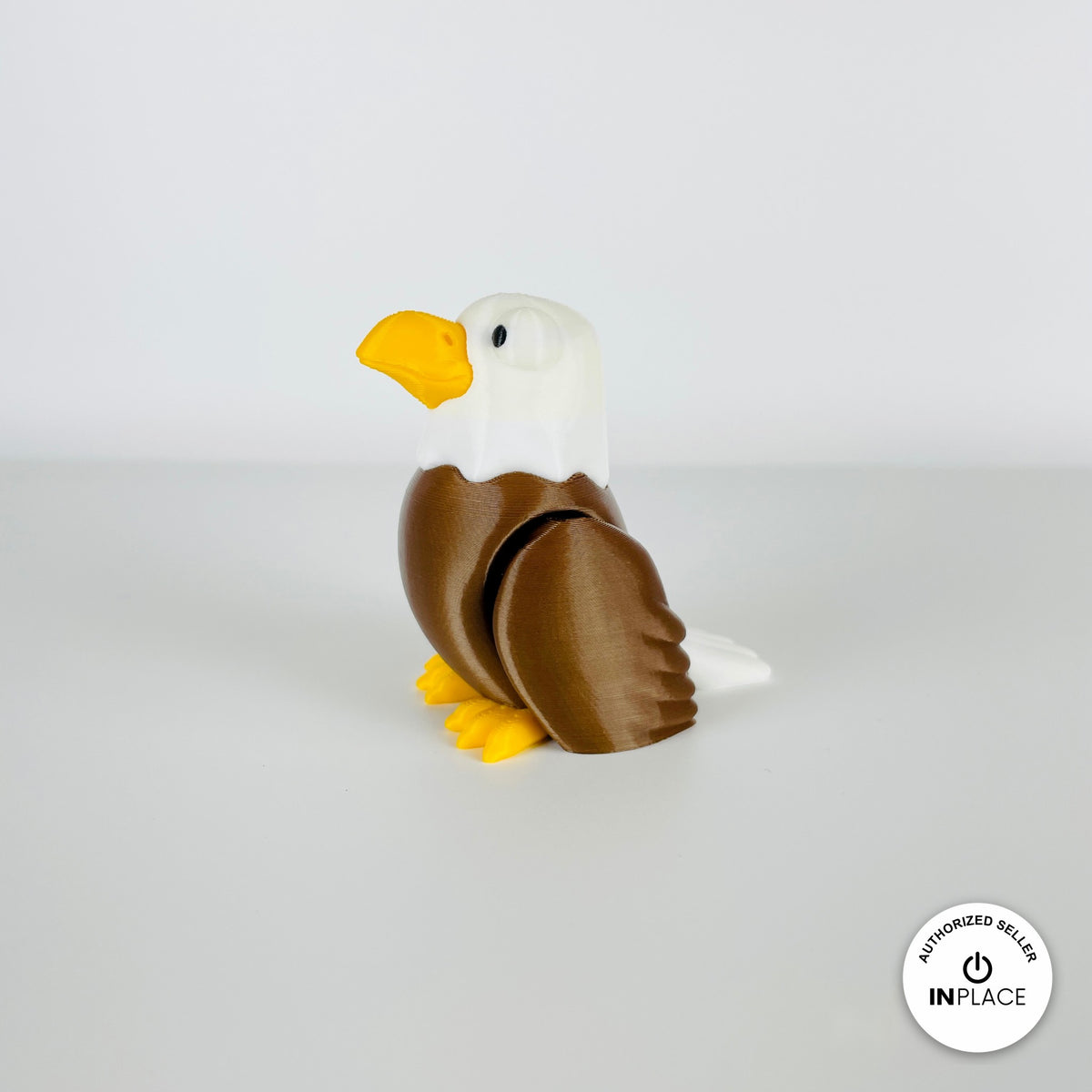 Cute bald eagle keychain, 3D printed by RU3D – standing looking left. Brown body, white head and yellow beak.