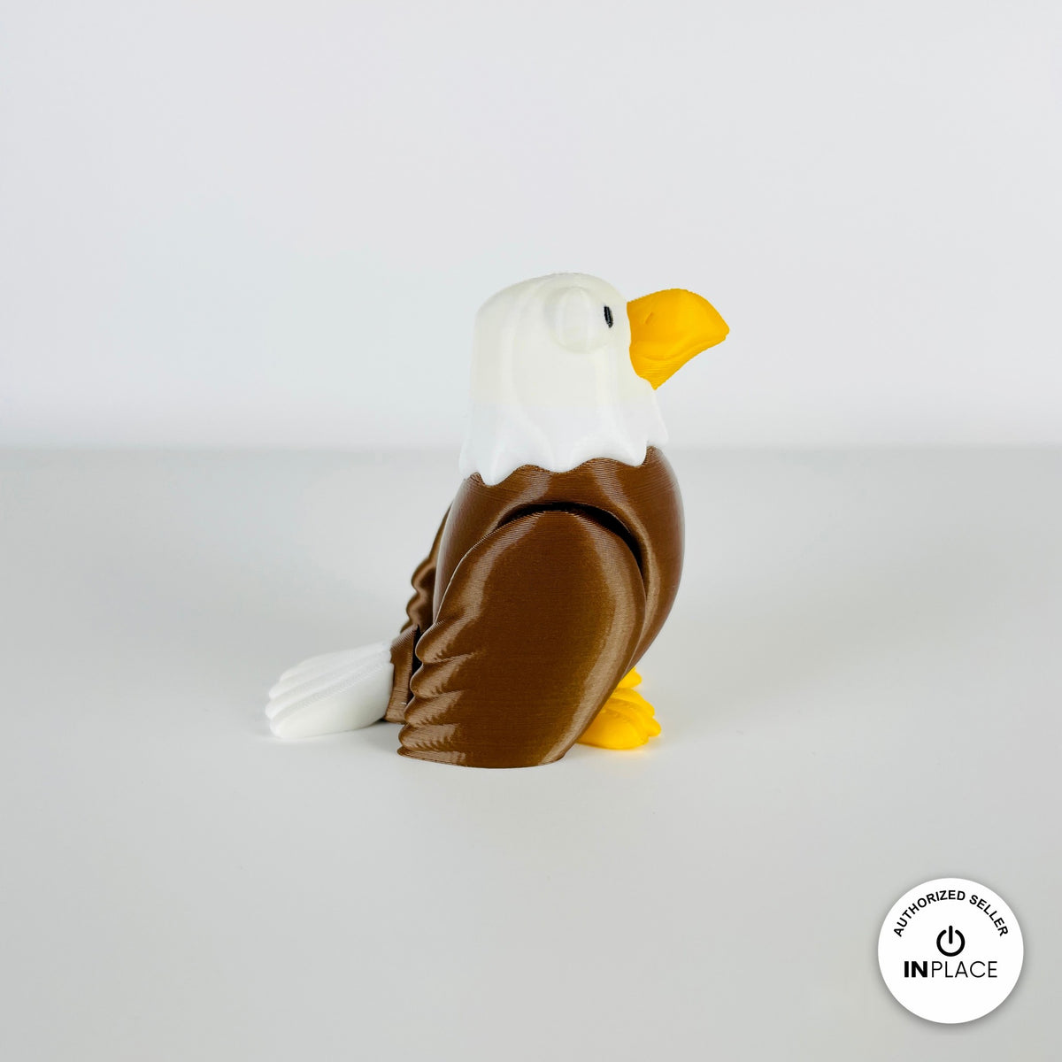 Cute bald eagle keychain, 3D printed by RU3D – standing looking right. Brown body, white head and yellow beak.