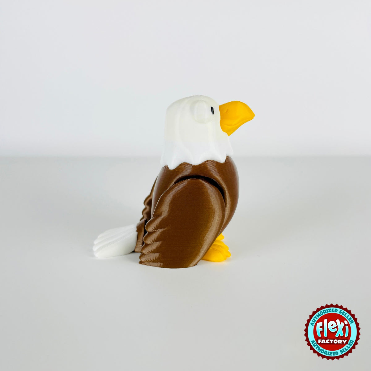 Cute bald eagle keychain, 3D printed by RU3D – standing looking right. Brown body, white head and yellow beak.