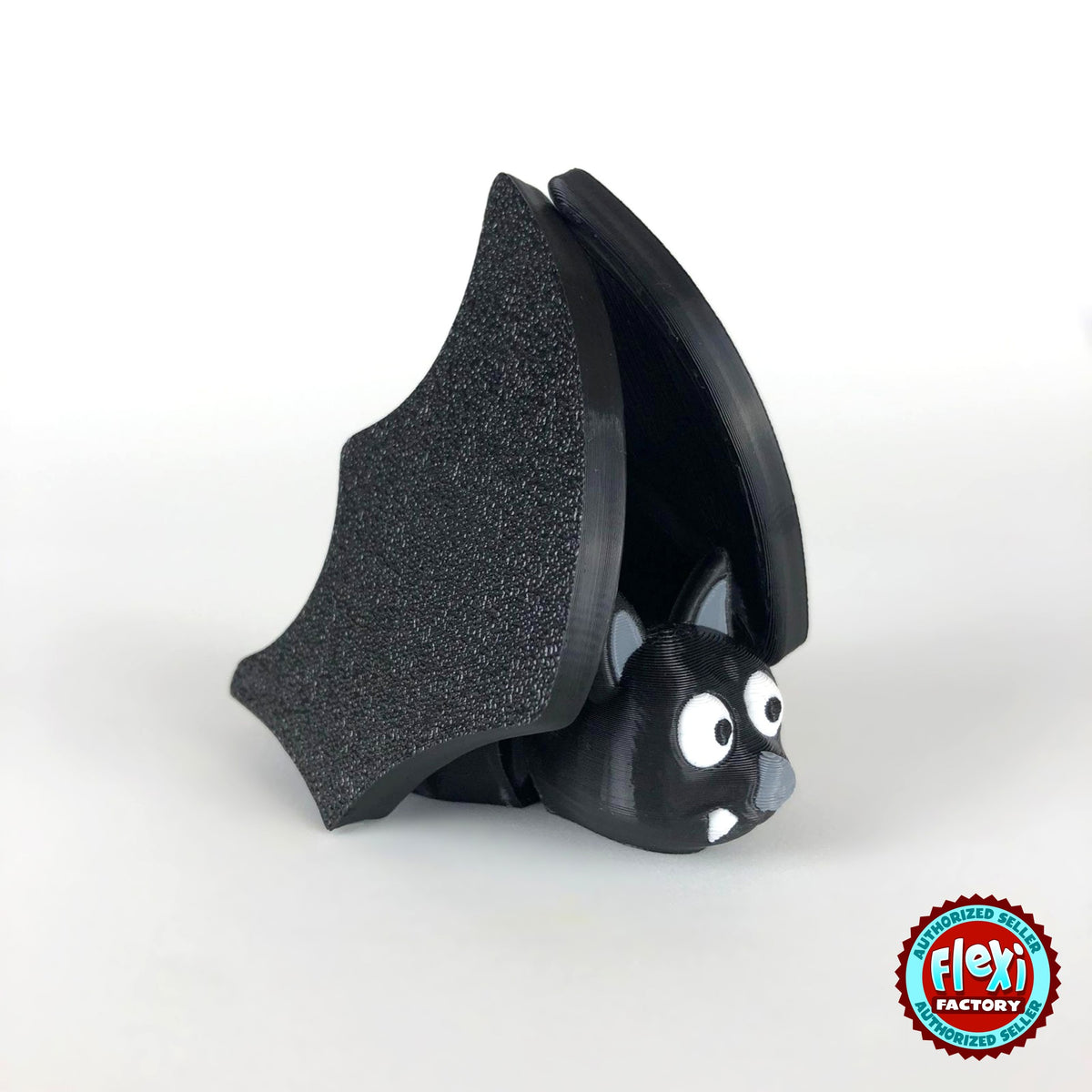 Cute bat keychain, 3D printed by RU3D – wings folded close up. Black with grey ears and white fangs.