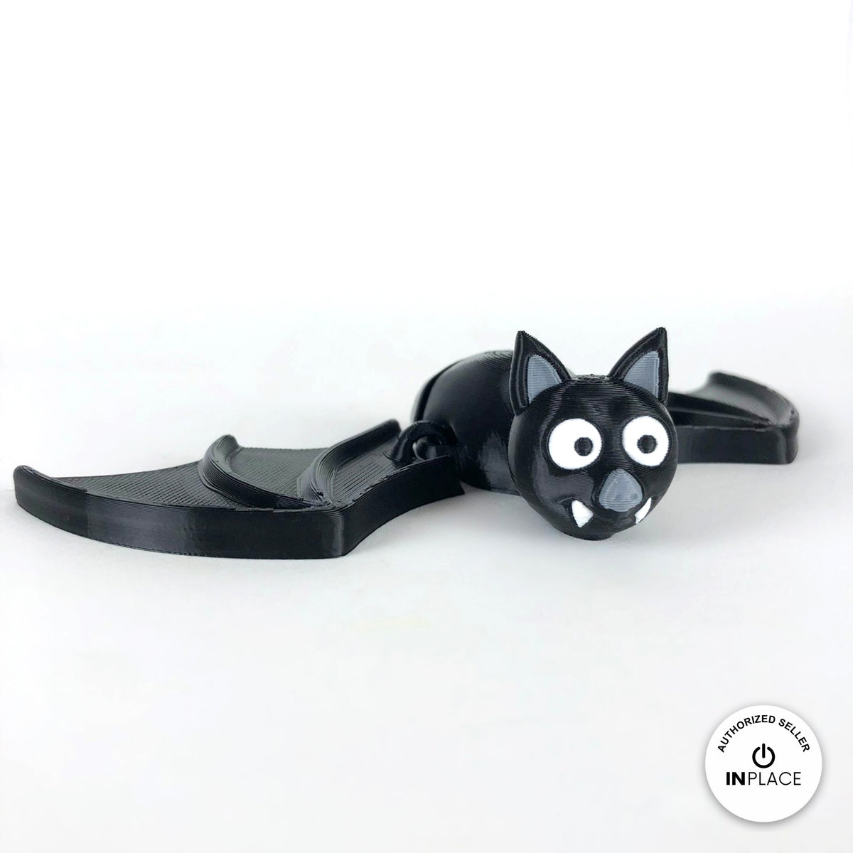 Cute bat keychain, 3D printed by RU3D – wings spread three quarter view. Black with grey ears and white fangs.