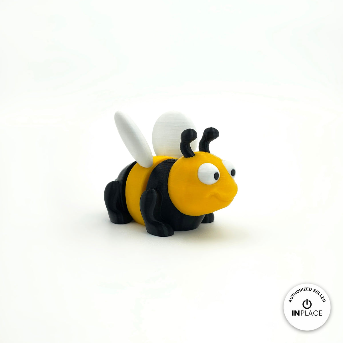 Cute bee keychain, 3D printed by RU3D – three quarter view facing right. Yellow and black with white wings.