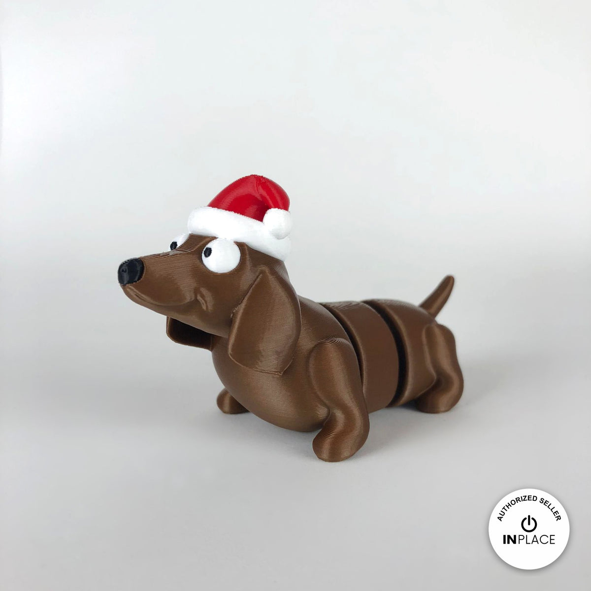 Cute Christmas dachshund keychain, 3D printed by RU3D – three quarter view facing left. Brown sausage dog with red Santa hat.