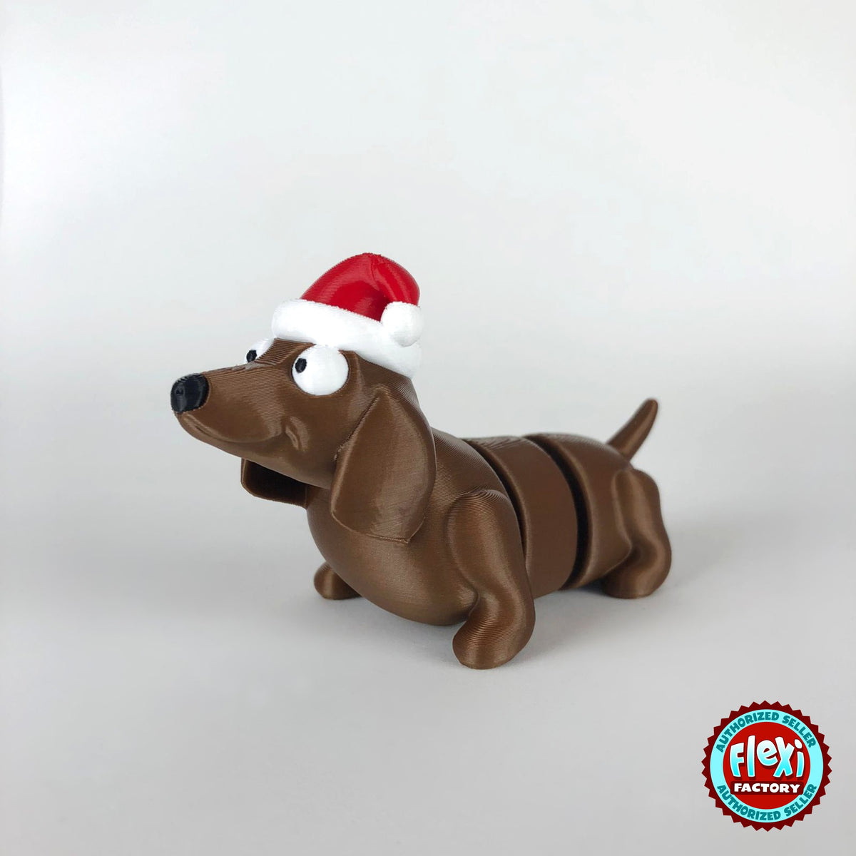 Cute Christmas dachshund keychain, 3D printed by RU3D – three quarter view facing left. Brown sausage dog with red Santa hat.