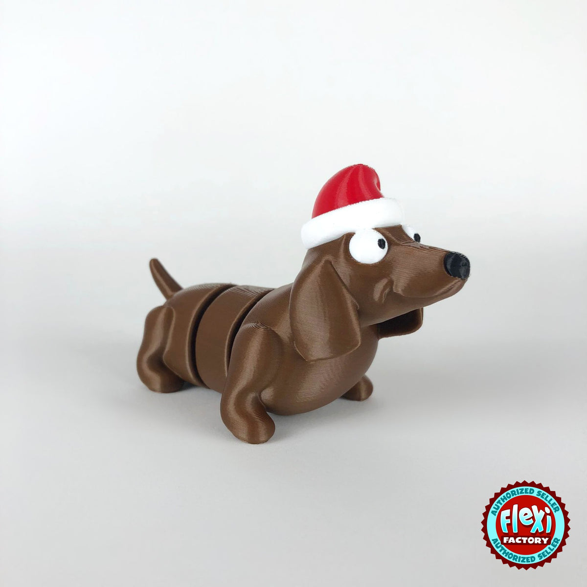Cute Christmas dachshund keychain, 3D printed by RU3D – three quarter view facing right. Brown sausage dog with red Santa hat.