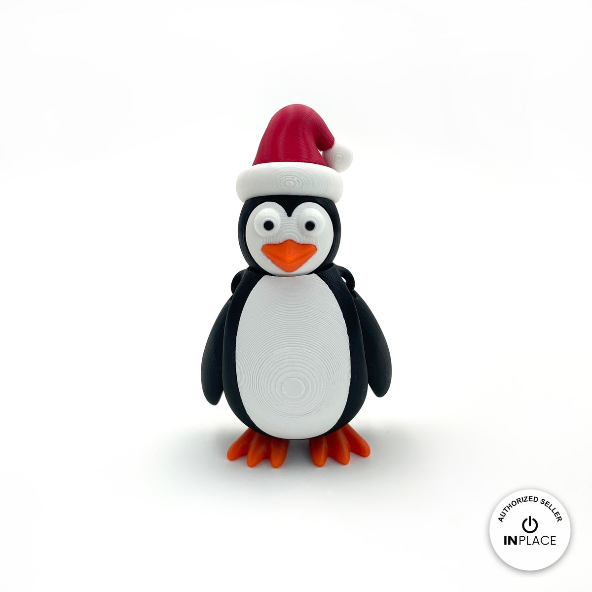 Cute Christmas penguin keychain, 3D printed by RU3D – front view. Black and white with red Santa hat and orange feet.