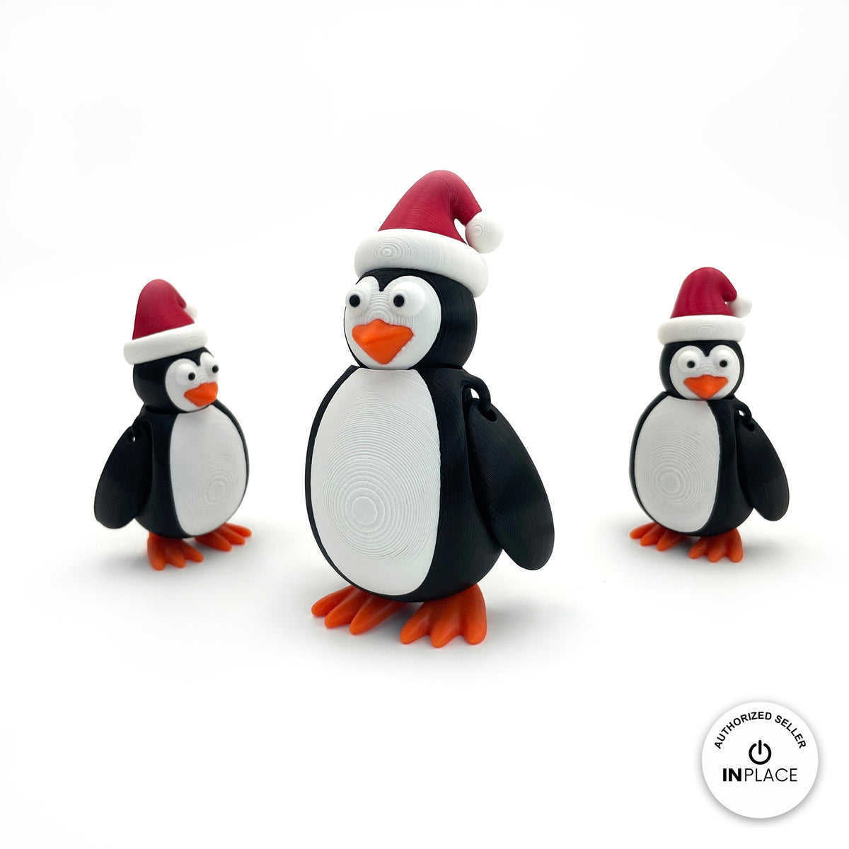 Cute Christmas penguin keychain, 3D printed by RU3D – group of Christmas penguins. Black and white with red Santa hat and orange feet.