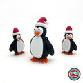Cute Christmas penguin keychain, 3D printed by RU3D – group of Christmas penguins. Black and white with red Santa hat and orange feet.