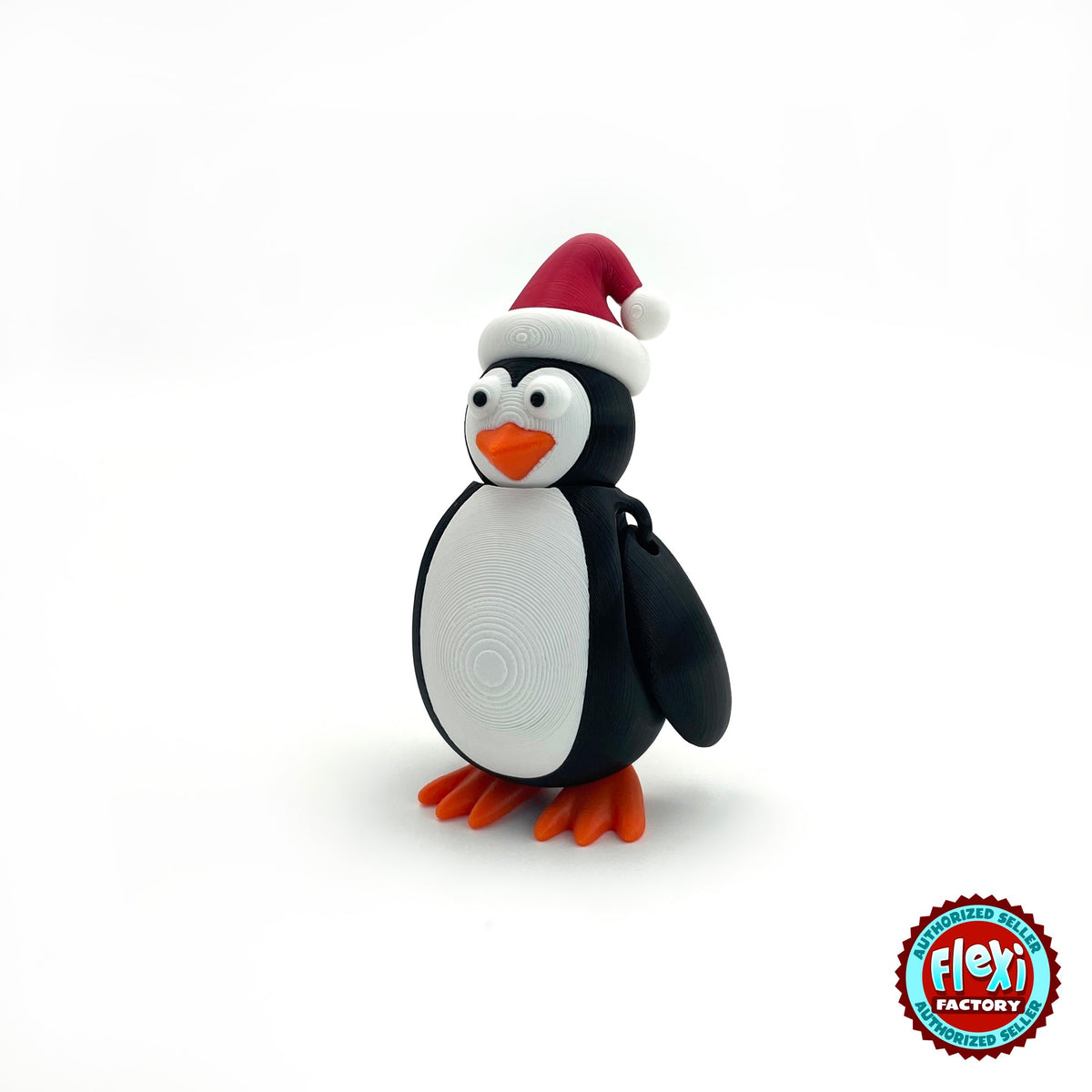 Cute Christmas penguin keychain, 3D printed by RU3D – three quarter view facing left. Black and white with red Santa hat and orange feet.