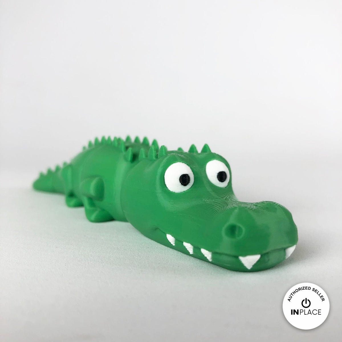 Cute crocodile keychain, 3D printed by RU3D – close up three quarter view. Green with white teeth.
