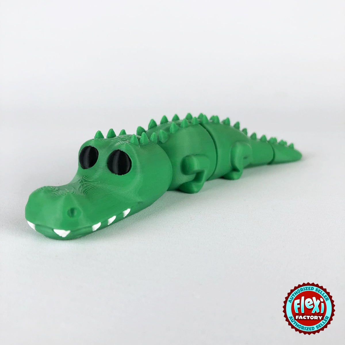 Cute crocodile keychain, 3D printed by RU3D – dark eyes three quarter view facing left. Green with white teeth.