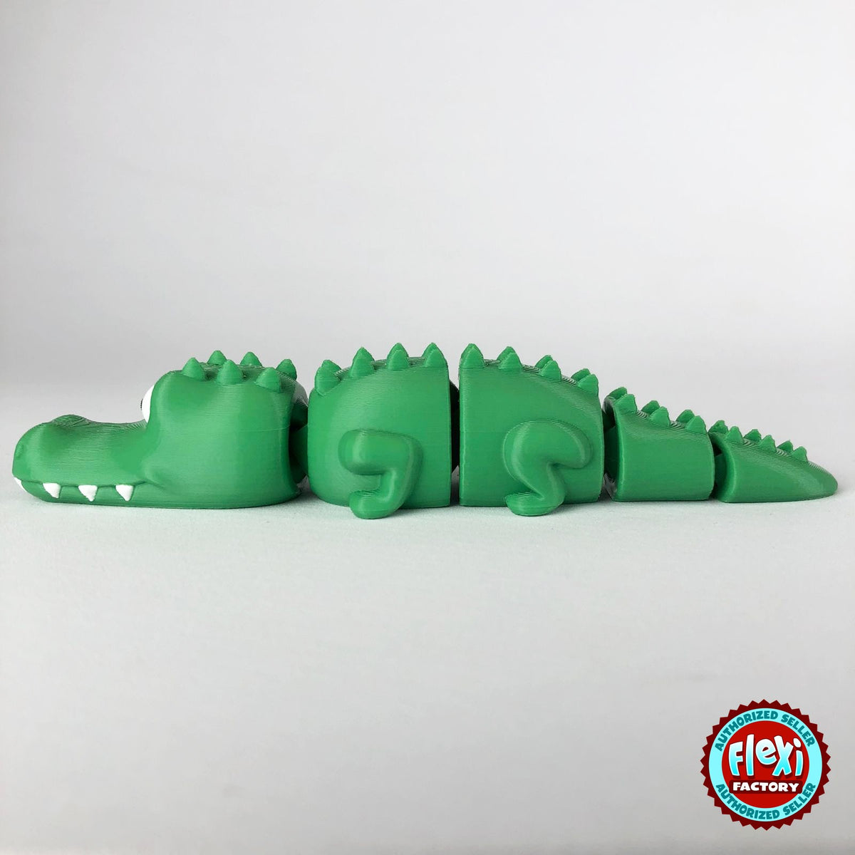 Cute crocodile keychain, 3D printed by RU3D – side view facing left tail right. Green with white teeth.