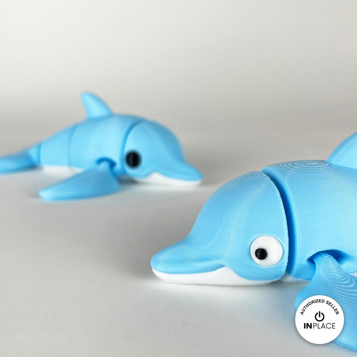 Cute dolphin keychain, 3D printed by RU3D – close up face with dolphin behind. Sky blue with white belly.