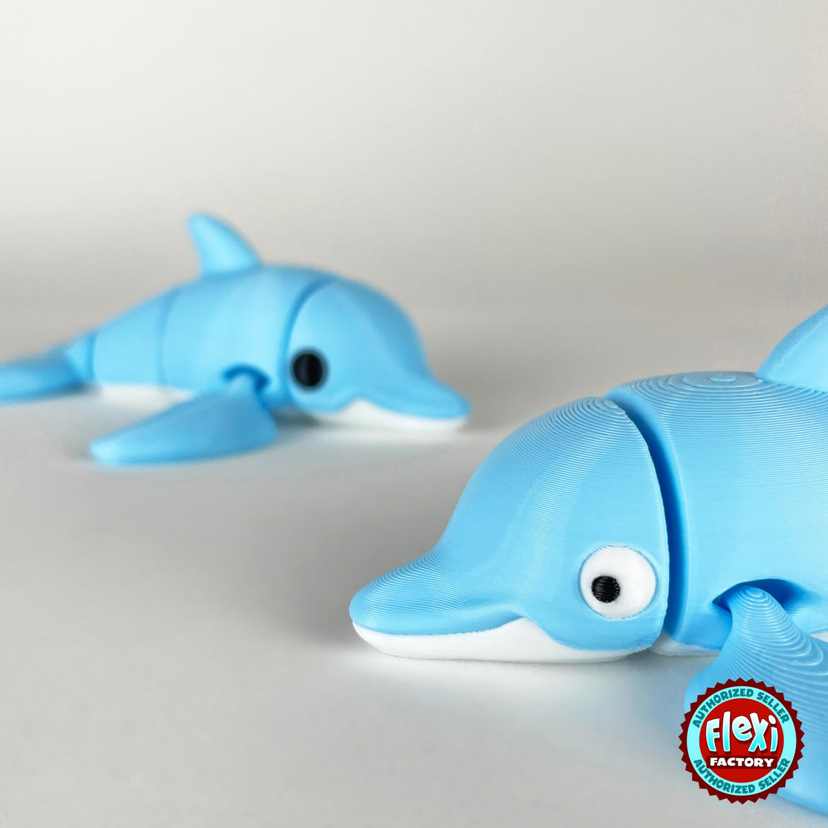 Cute dolphin keychain, 3D printed by RU3D – close up face with dolphin behind. Sky blue with white belly.