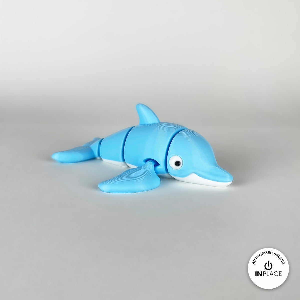 Cute dolphin keychain, 3D printed by RU3D – side view facing right. Sky blue with white belly.