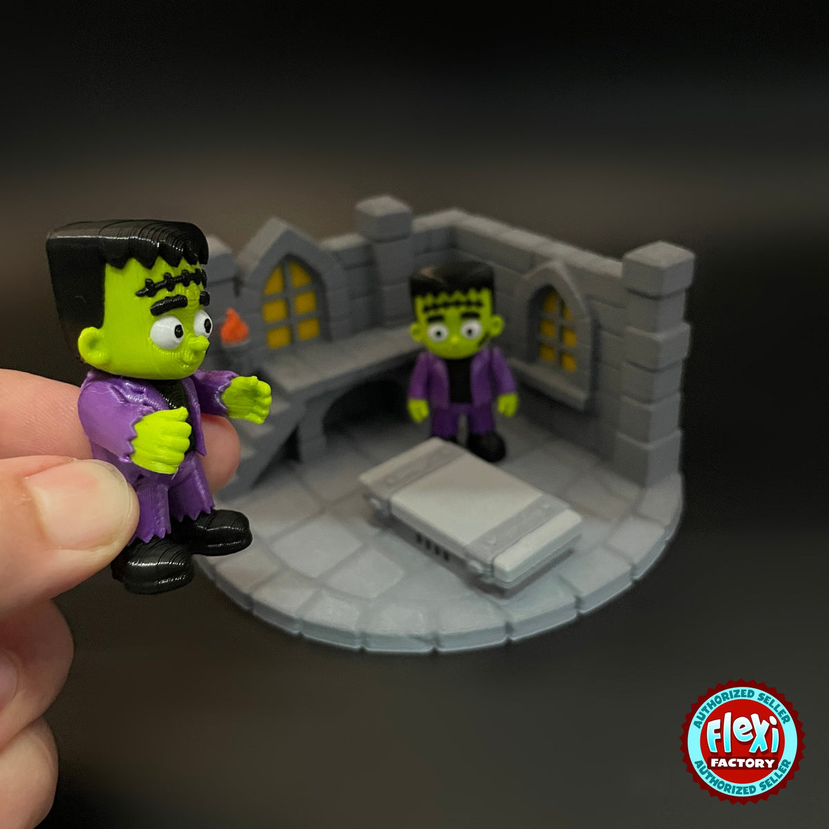 Cute Frankenstein monster keychain, 3D printed by RU3D – held in hand with laboratory playset. Green skin, purple jacket with laboratory playset.
