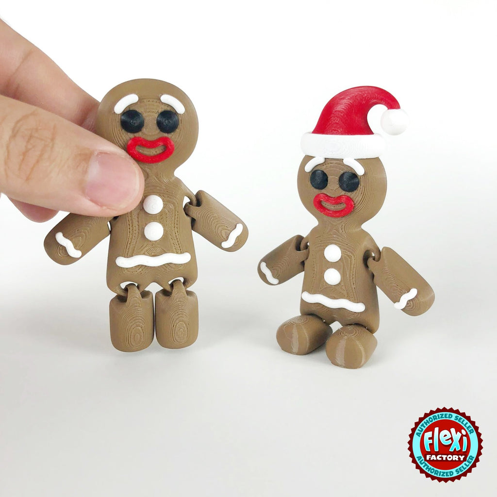 Cute gingerbread man keychain, 3D printed by RU3D – dark eyes held in hand with Santa hat friend. Brown with white icing and red Santa hat.