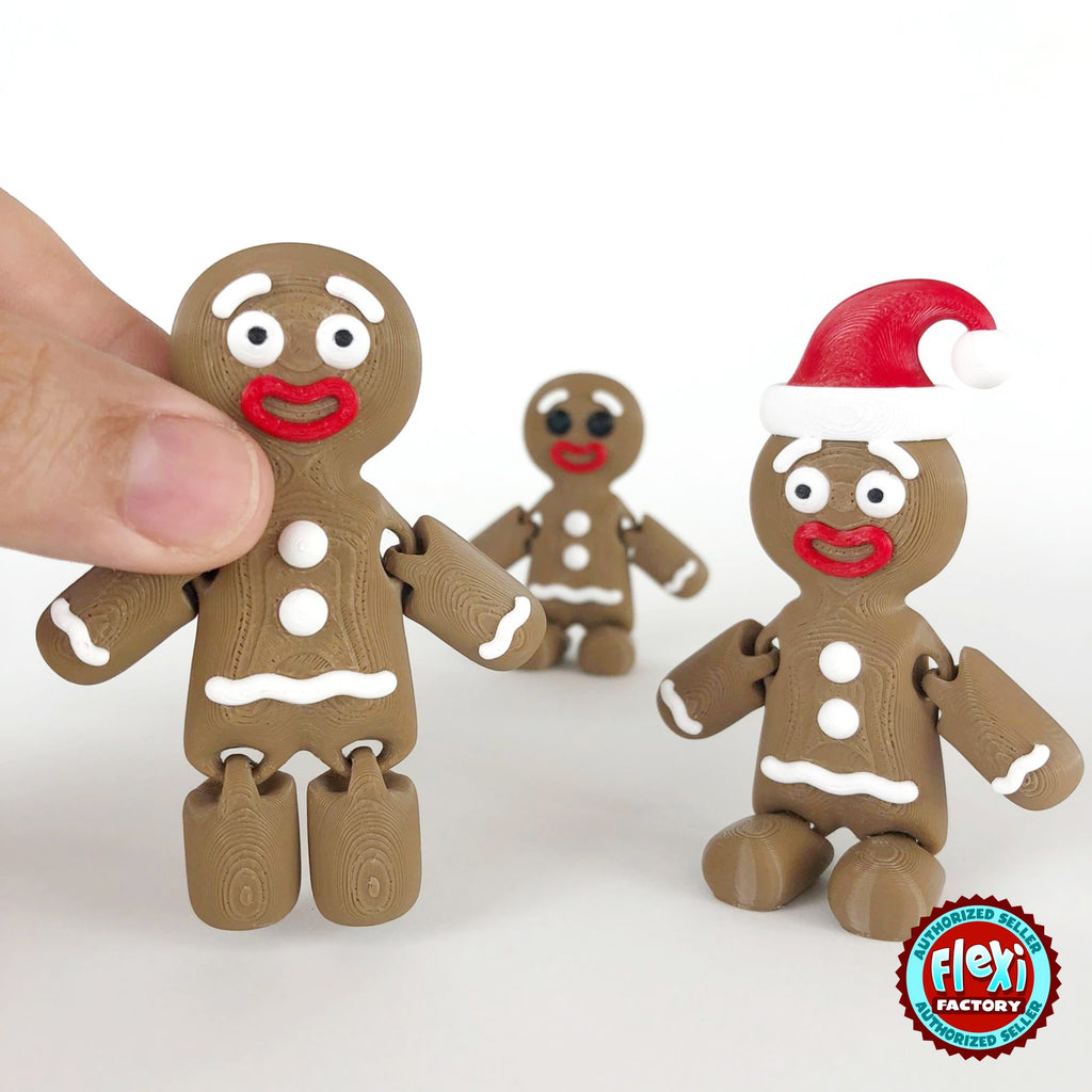 Cute gingerbread man keychain, 3D printed by RU3D – held in hand with friends. Brown with white icing and red Santa hat.