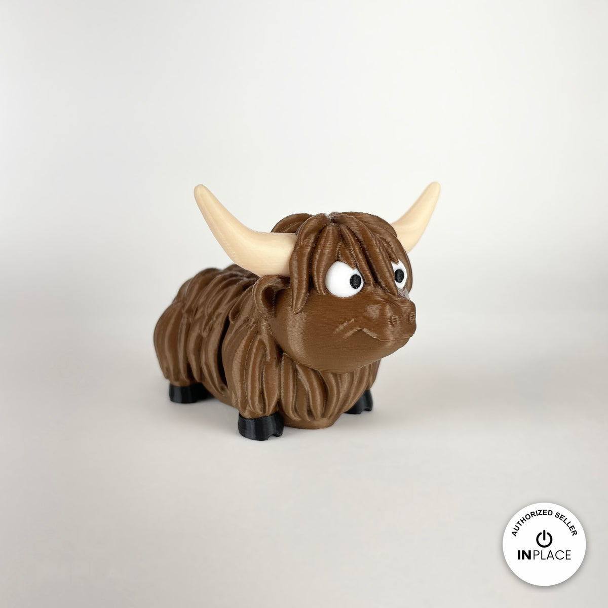 Cute Highland cow keychain, 3D printed by RU3D – three quarter view facing right looking up. Shaggy brown with cream horns.