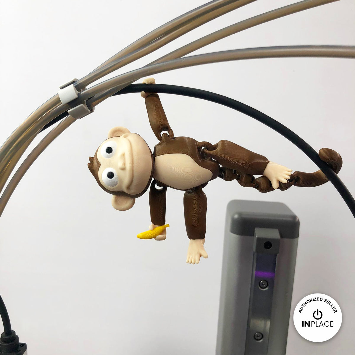Cute monkey keychain, 3D printed by RU3D – hanging by arm and tail. Brown with cream face and yellow banana.