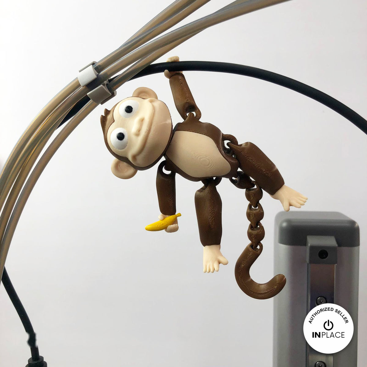 Cute monkey keychain, 3D printed by RU3D – hanging by tail. Brown with cream face and yellow banana.