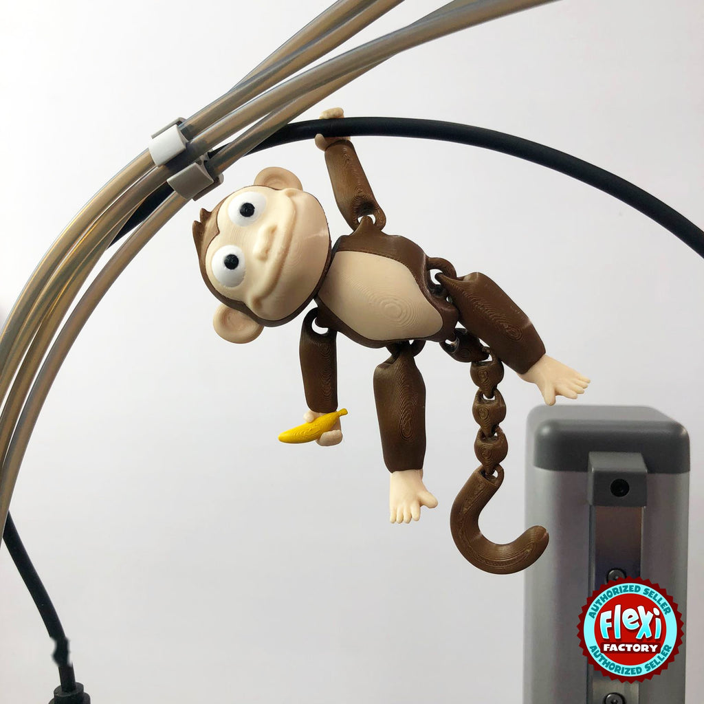 Cute monkey keychain, 3D printed by RU3D – hanging by tail. Brown with cream face and yellow banana.