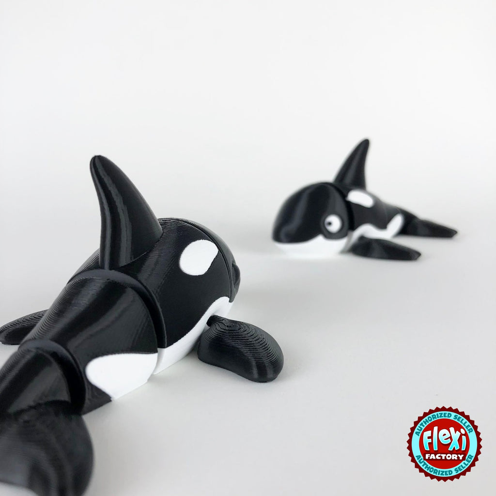Cute orca killer whale keychain, 3D printed by RU3D – close up with orca behind. Black and white.
