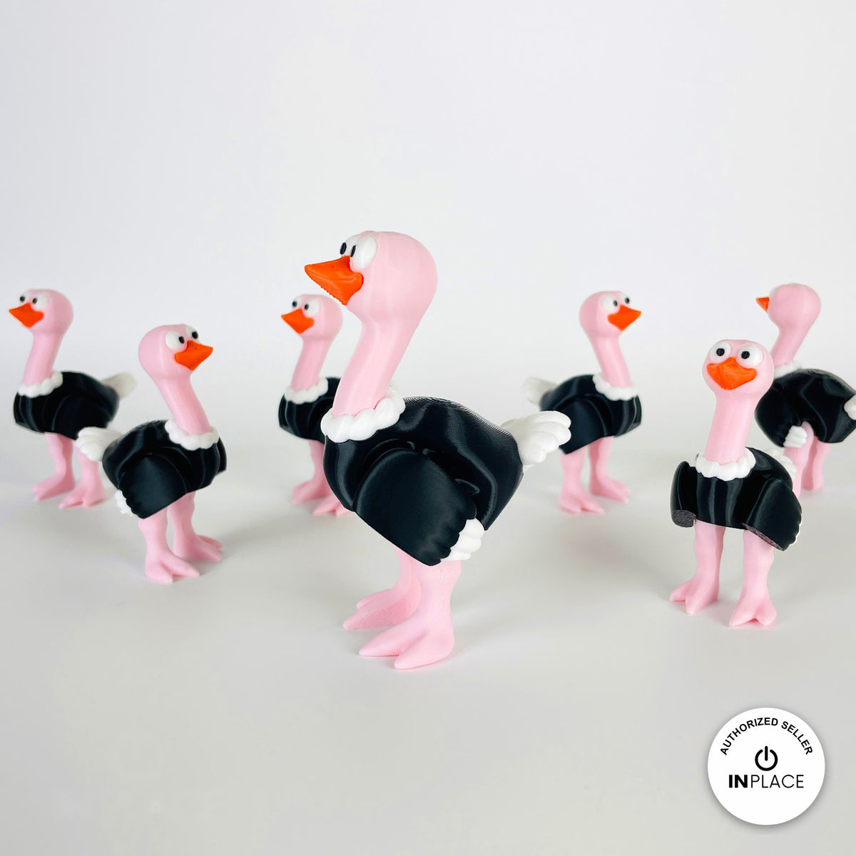 Cute ostrich keychain, 3D printed by RU3D – group of ostriches facing left. Pink neck and legs with black feathers.