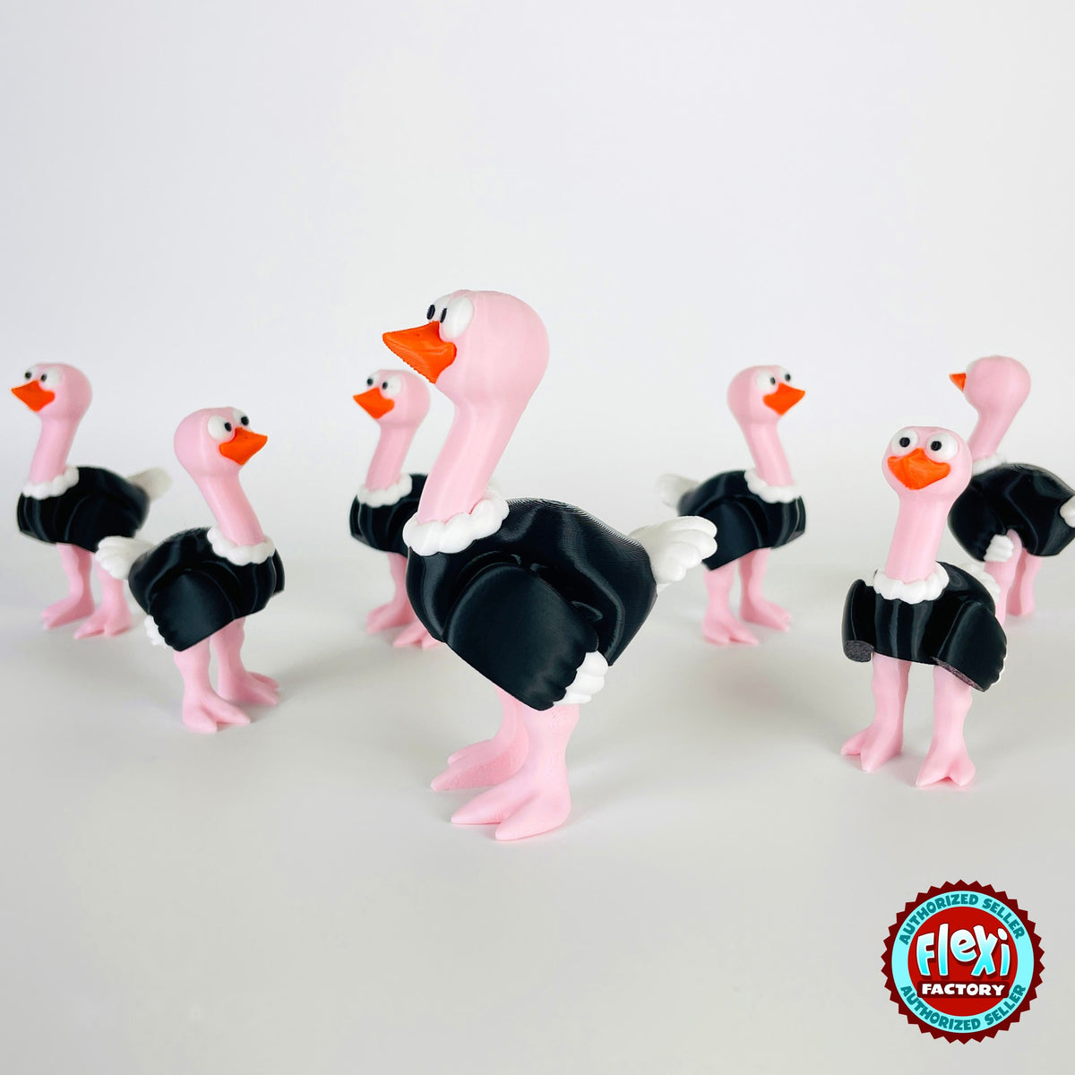 Cute ostrich keychain, 3D printed by RU3D – group of ostriches facing left. Pink neck and legs with black feathers.