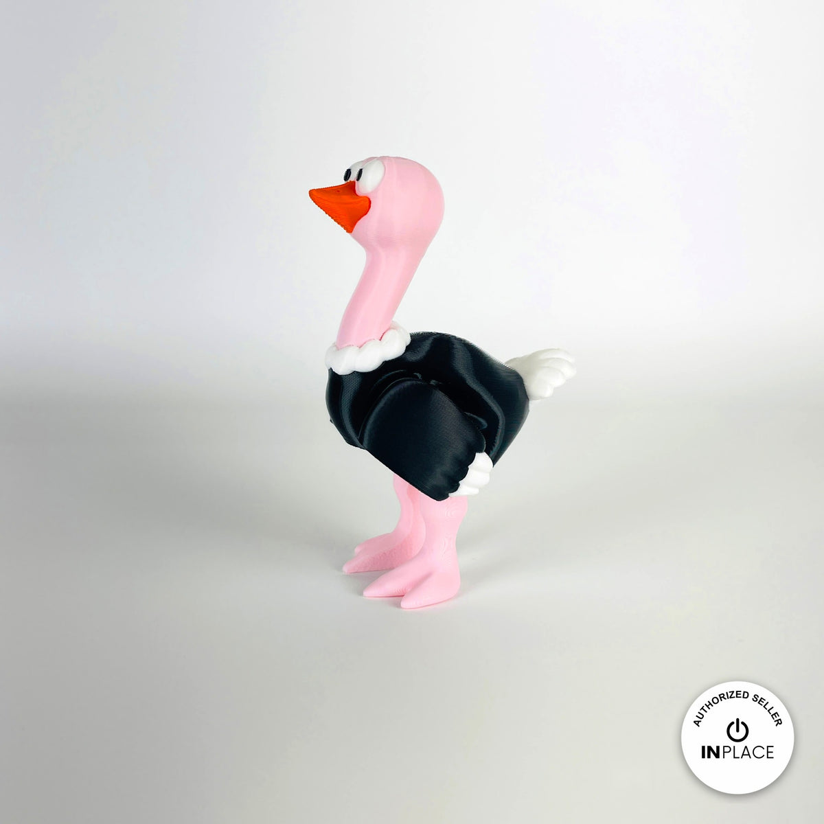 Cute ostrich keychain, 3D printed by RU3D – standing three quarter view facing left. Pink neck and legs with black feathers.