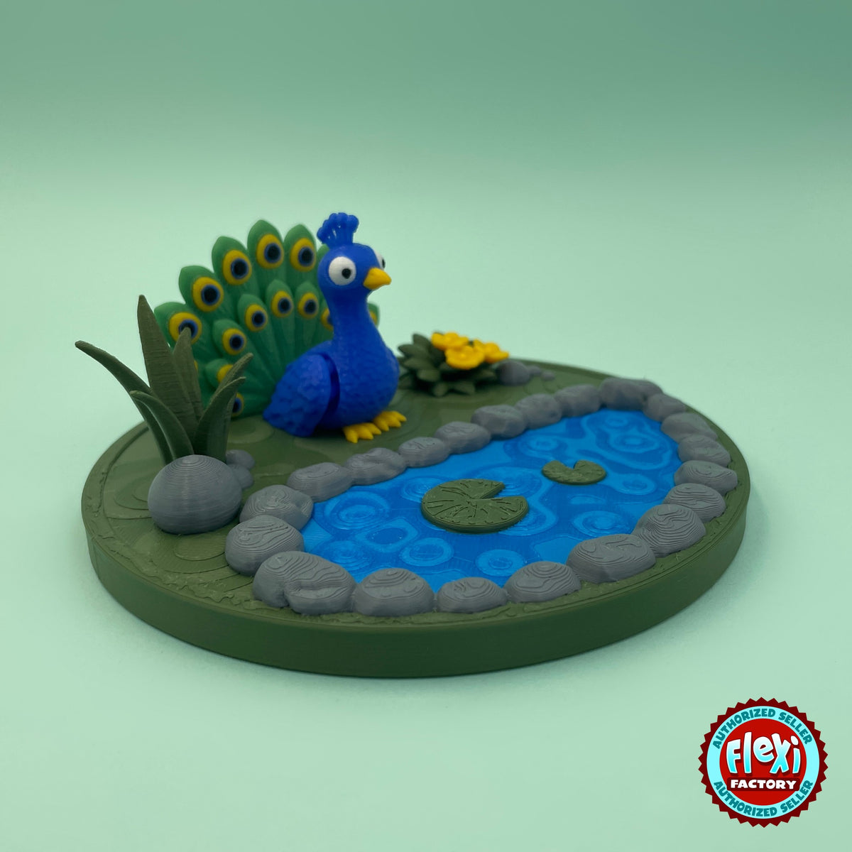 Cute peacock keychain, 3D printed by RU3D – side view with pond garden. Royal blue with green feather tail and pond garden playset.