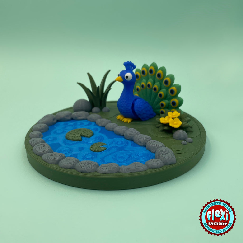 Cute peacock keychain, 3D printed by RU3D – three quarter view with pond garden. Royal blue with green feather tail and pond garden playset.