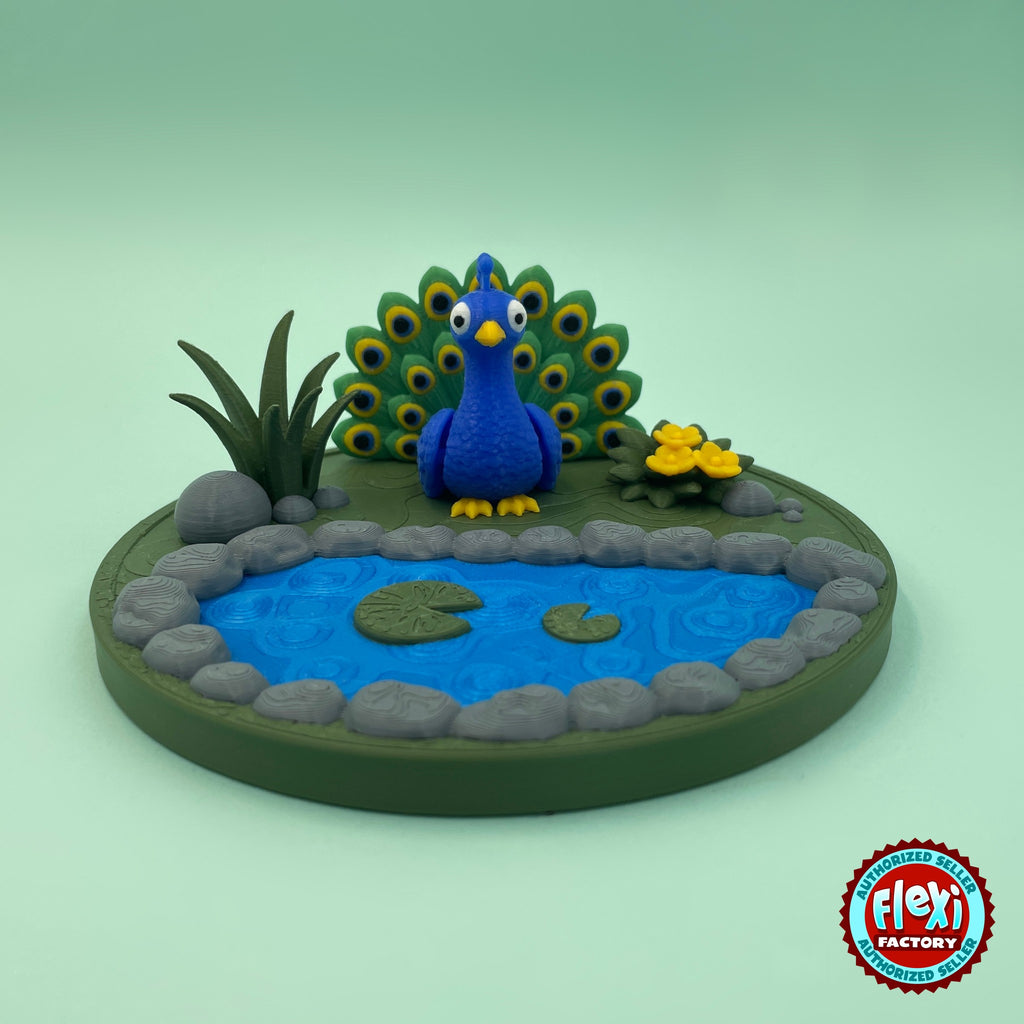 Cute peacock keychain, 3D printed by RU3D – with pond garden playset. Royal blue with green feather tail and pond garden playset.