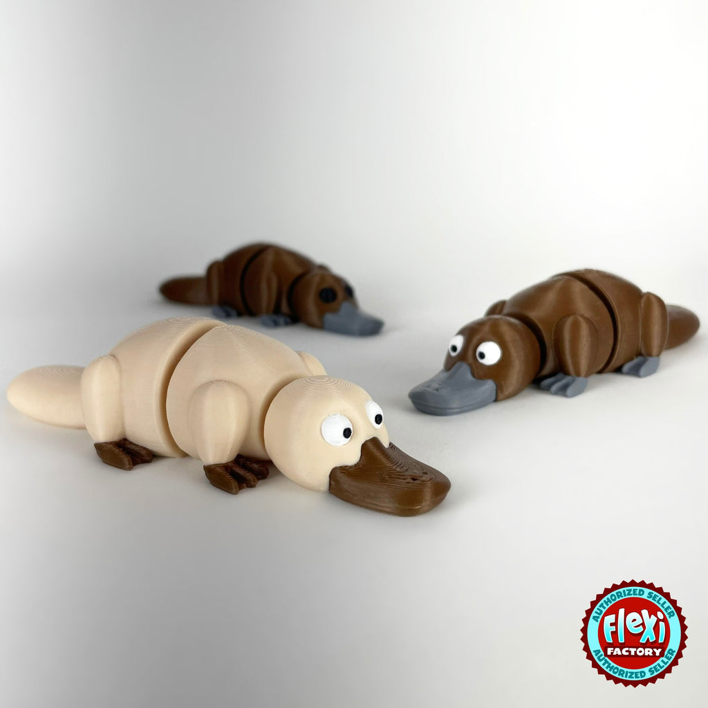 Cute platypus keychain, 3D printed by RU3D – group of platypuses cream in front. Brown with grey bill, also in cream.