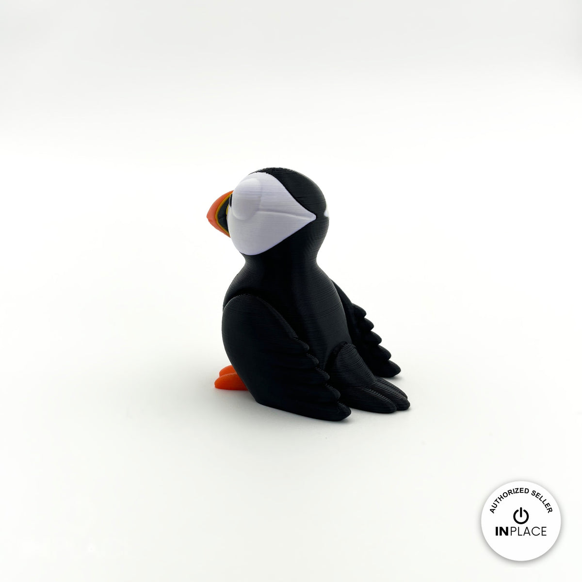 Cute puffin keychain, 3D printed by RU3D – side view facing left. Black and white with orange beak and feet.