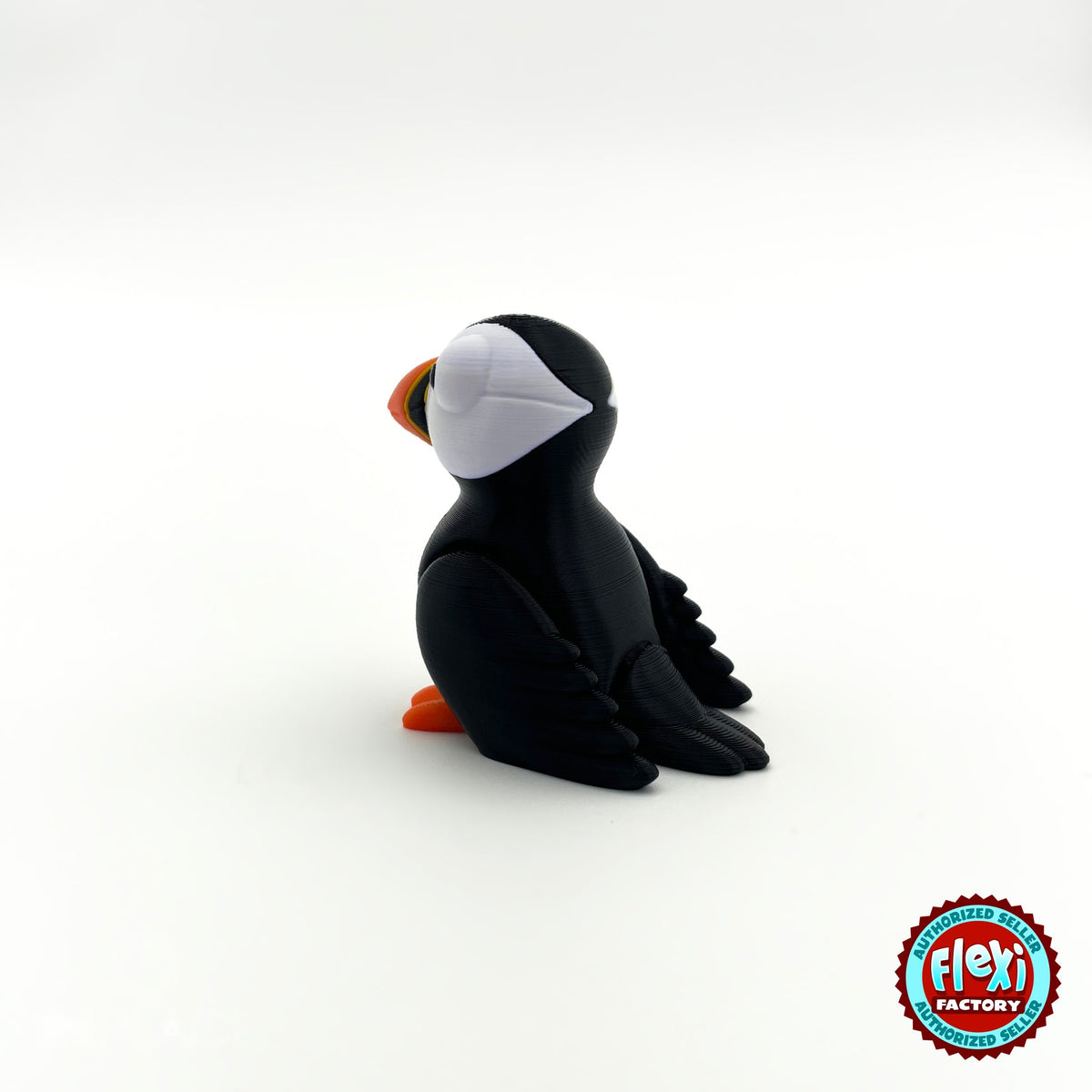 Cute puffin keychain, 3D printed by RU3D – side view facing left. Black and white with orange beak and feet.