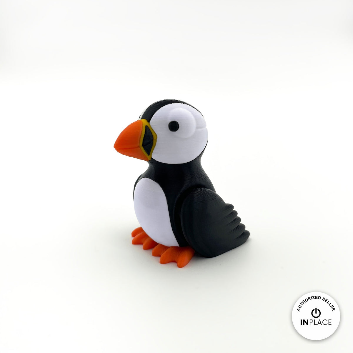 Cute puffin keychain, 3D printed by RU3D – three quarter view facing left. Black and white with orange beak and feet.