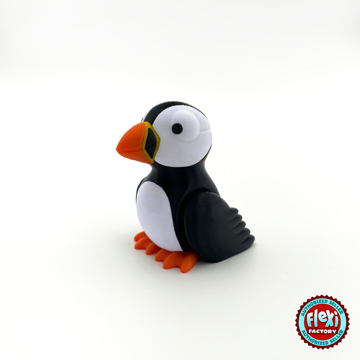 Cute puffin keychain, 3D printed by RU3D – three quarter view facing left. Black and white with orange beak and feet.