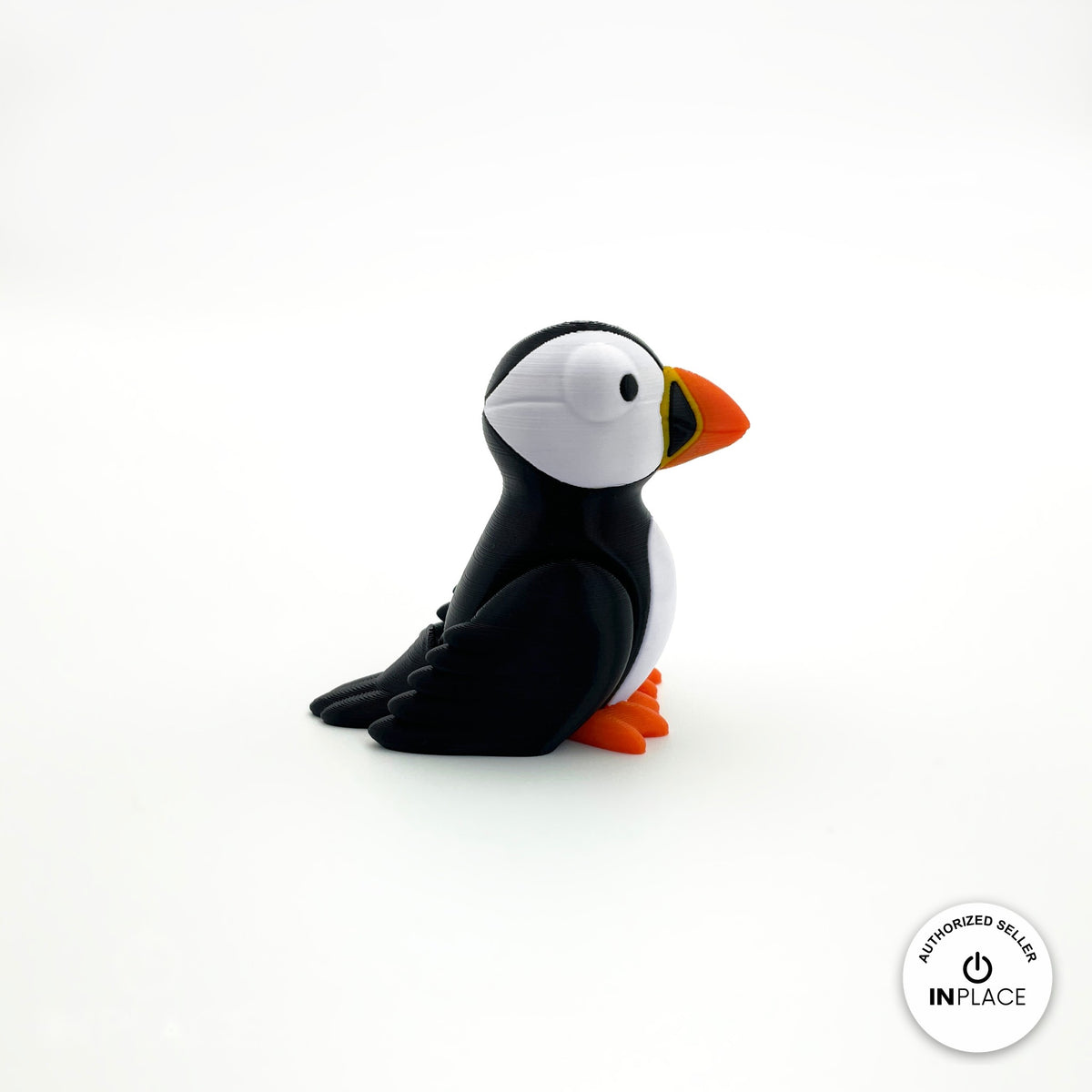 Cute puffin keychain, 3D printed by RU3D – three quarter view facing right. Black and white with orange beak and feet.