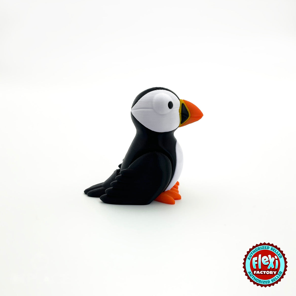 Cute puffin keychain, 3D printed by RU3D – three quarter view facing right. Black and white with orange beak and feet.