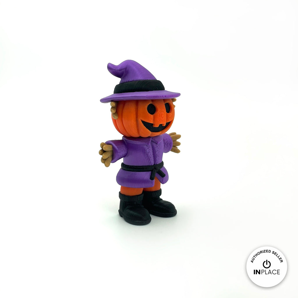 Cute pumpkin scarecrow keychain, 3D printed by RU3D – three quarter view facing left. Orange pumpkin head with purple hat and outfit.