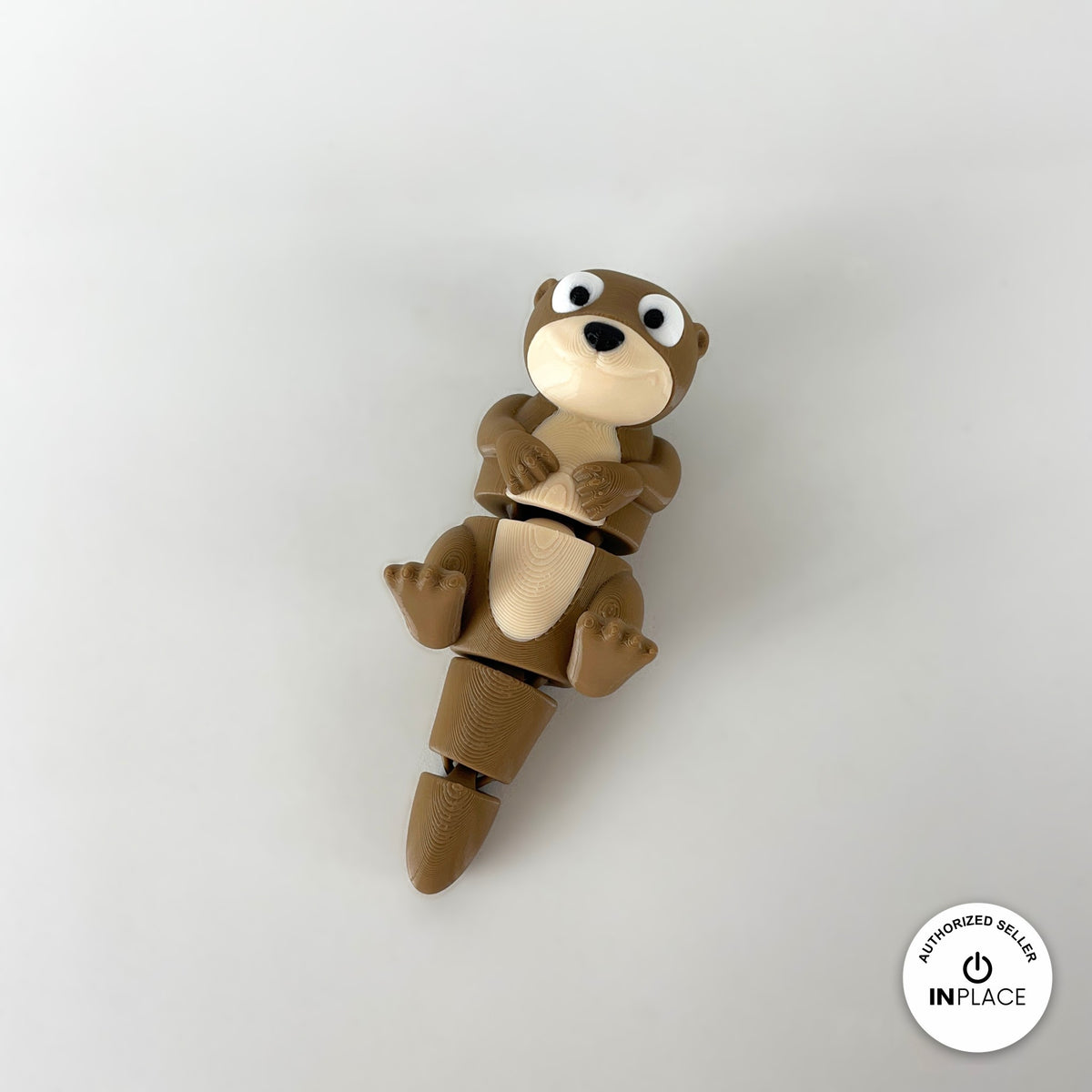 Cute river otter keychain, 3D printed by RU3D – floating on back top view. Brown with cream belly.