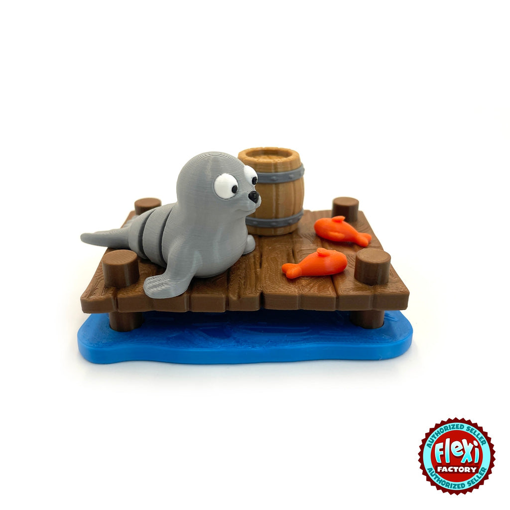 Cute seal keychain, 3D printed by RU3D – three quarter view on dock with fish. Grey with wooden dock playset.