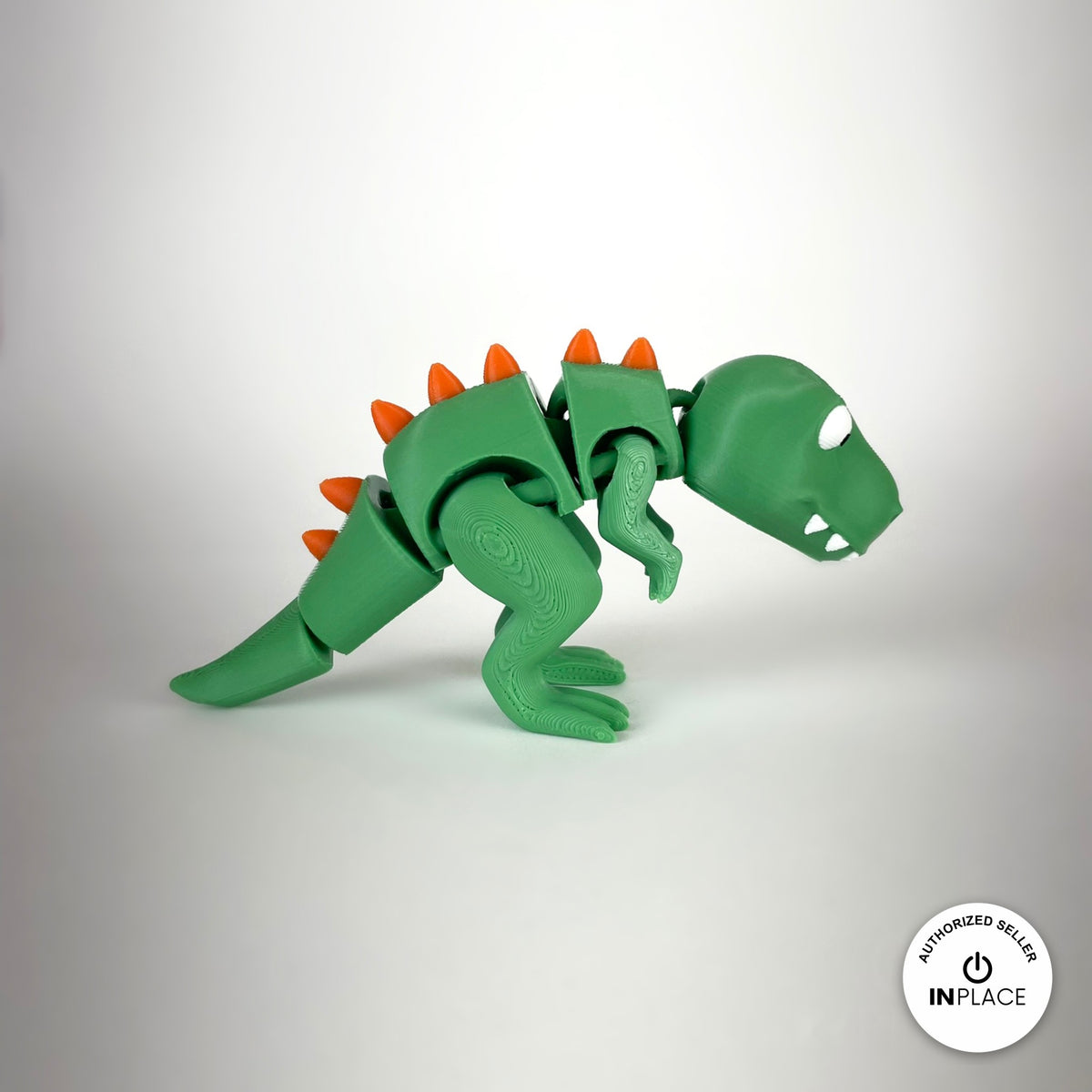 Cute T Rex dinosaur keychain, 3D printed by RU3D – side view facing right. Green with orange spikes.