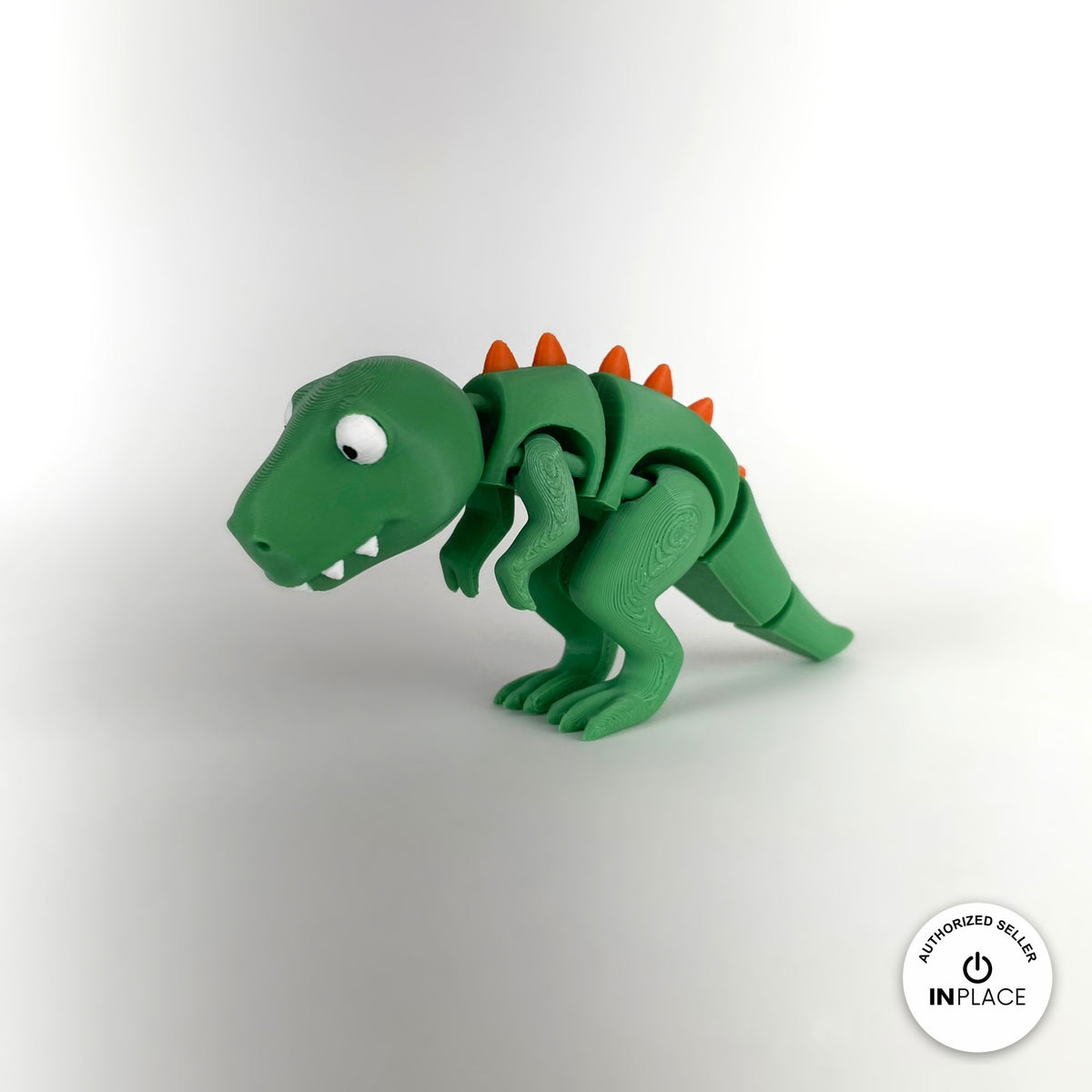 Cute T Rex dinosaur keychain, 3D printed by RU3D – three quarter view facing left. Green with orange spikes.
