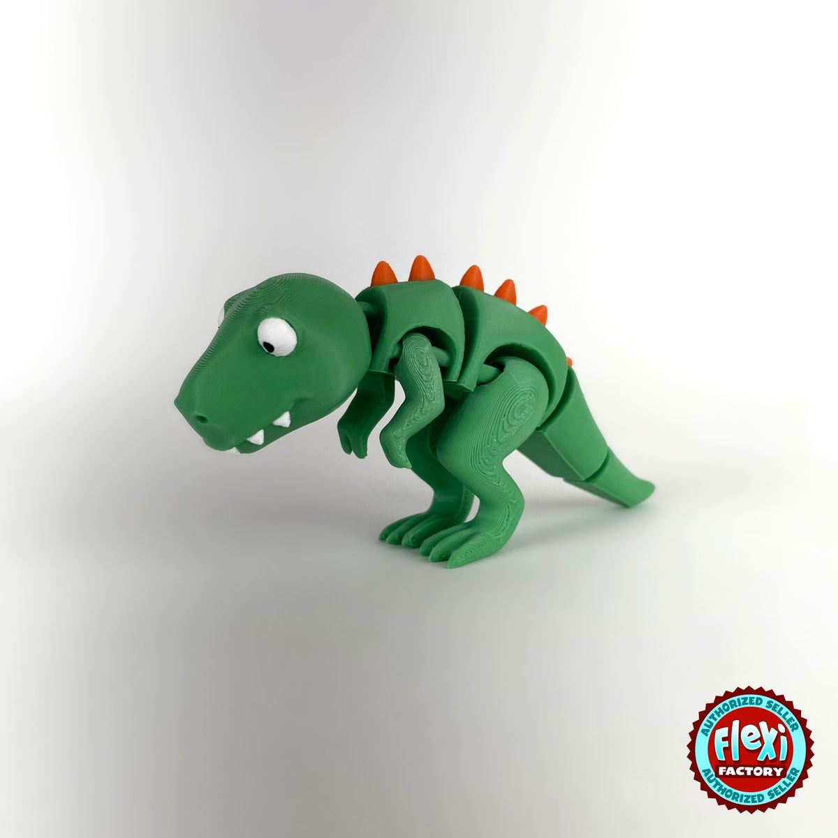 Cute T Rex dinosaur keychain, 3D printed by RU3D – three quarter view facing left. Green with orange spikes.